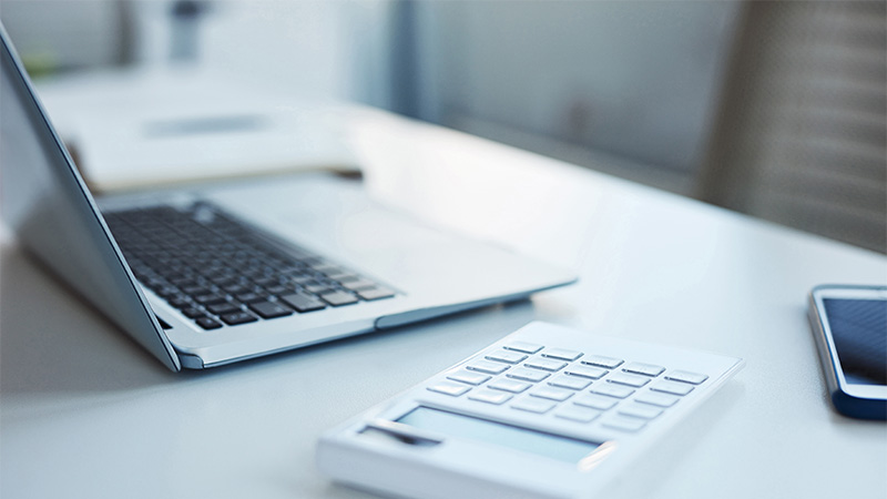 Notebook e calculadora em cima de uma mesa